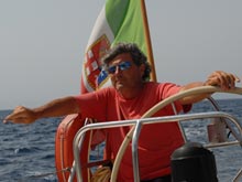 Eugenio weating sunglasses, at the helm of his sailing boat